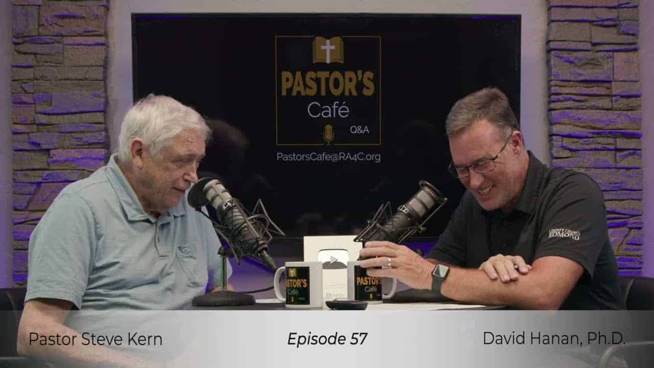 Two pastors engaged in a training session at Liberty Pastors Cafe with microphones and coffee mugs.