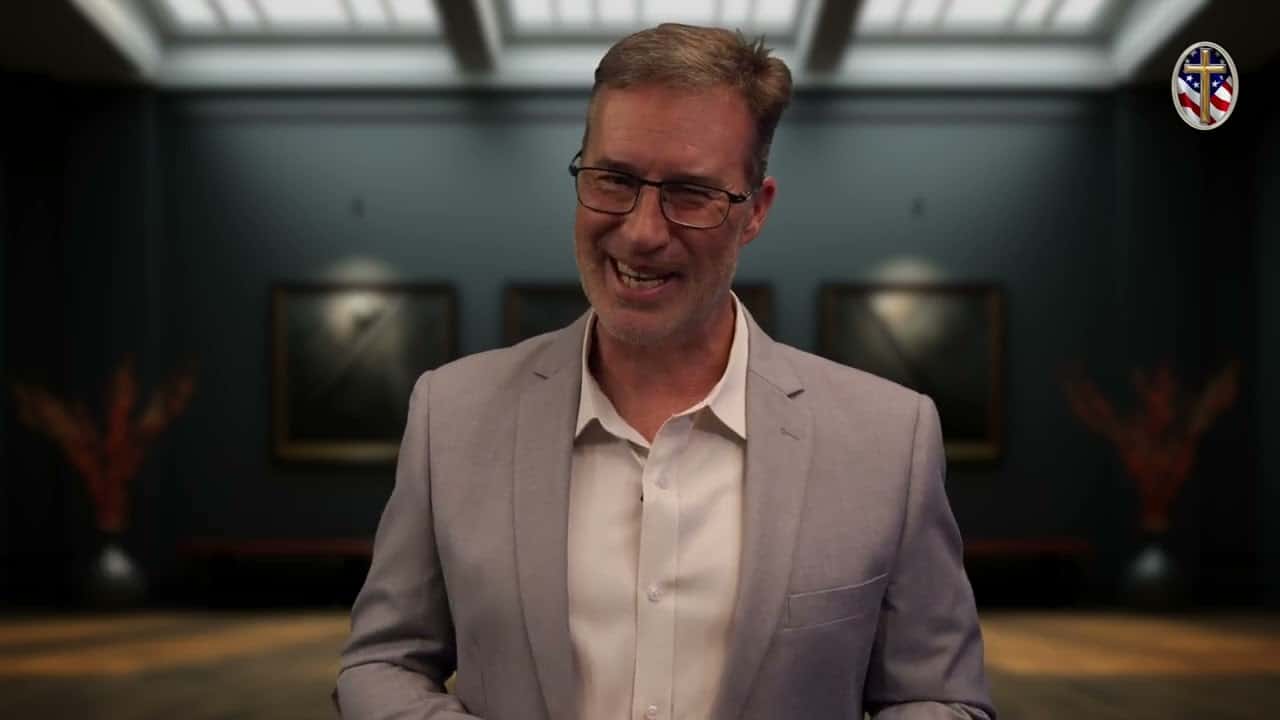 Man smiling at Liberty Pastors Training event in a gallery setting.